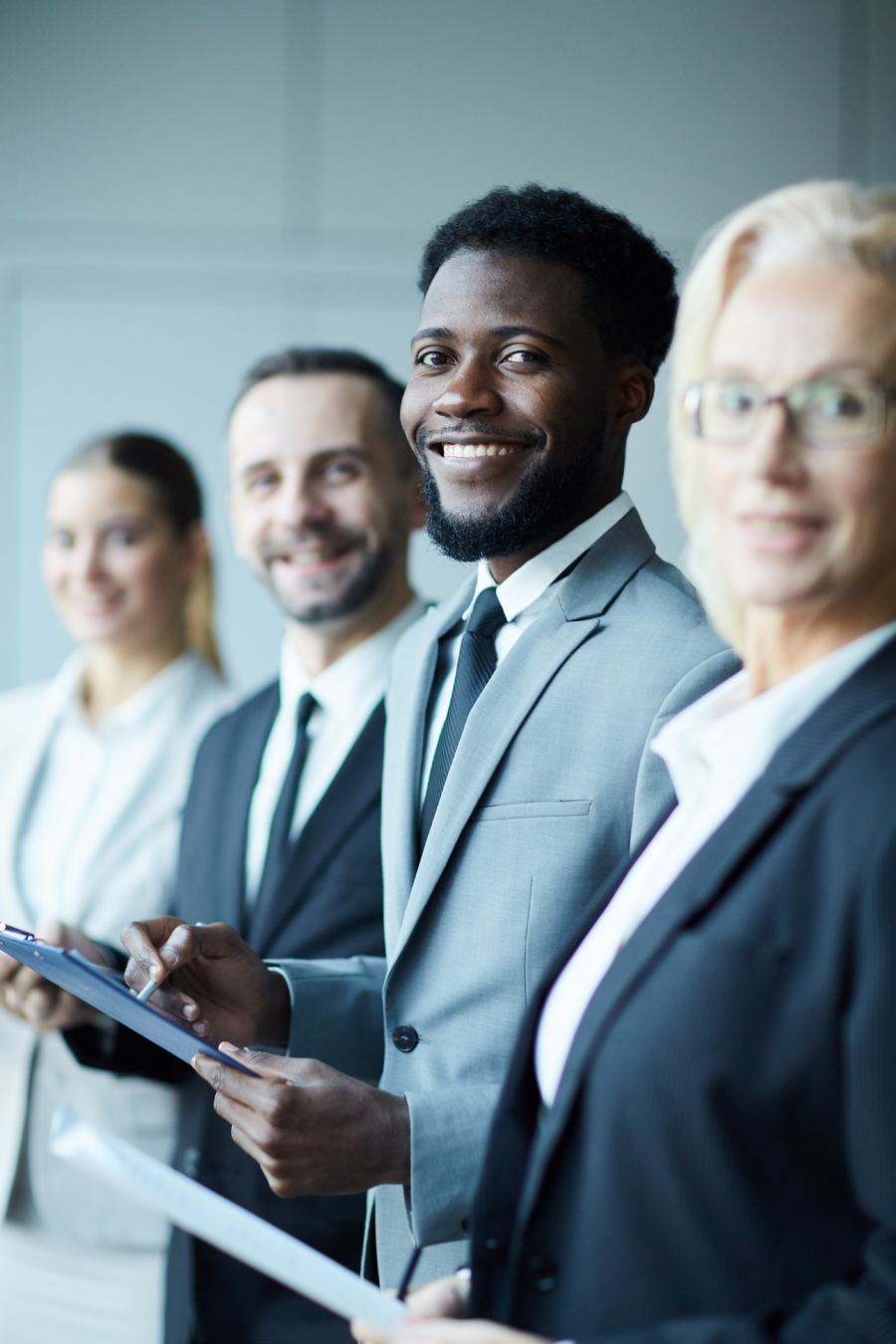 A team of smiling business professionals holding documents